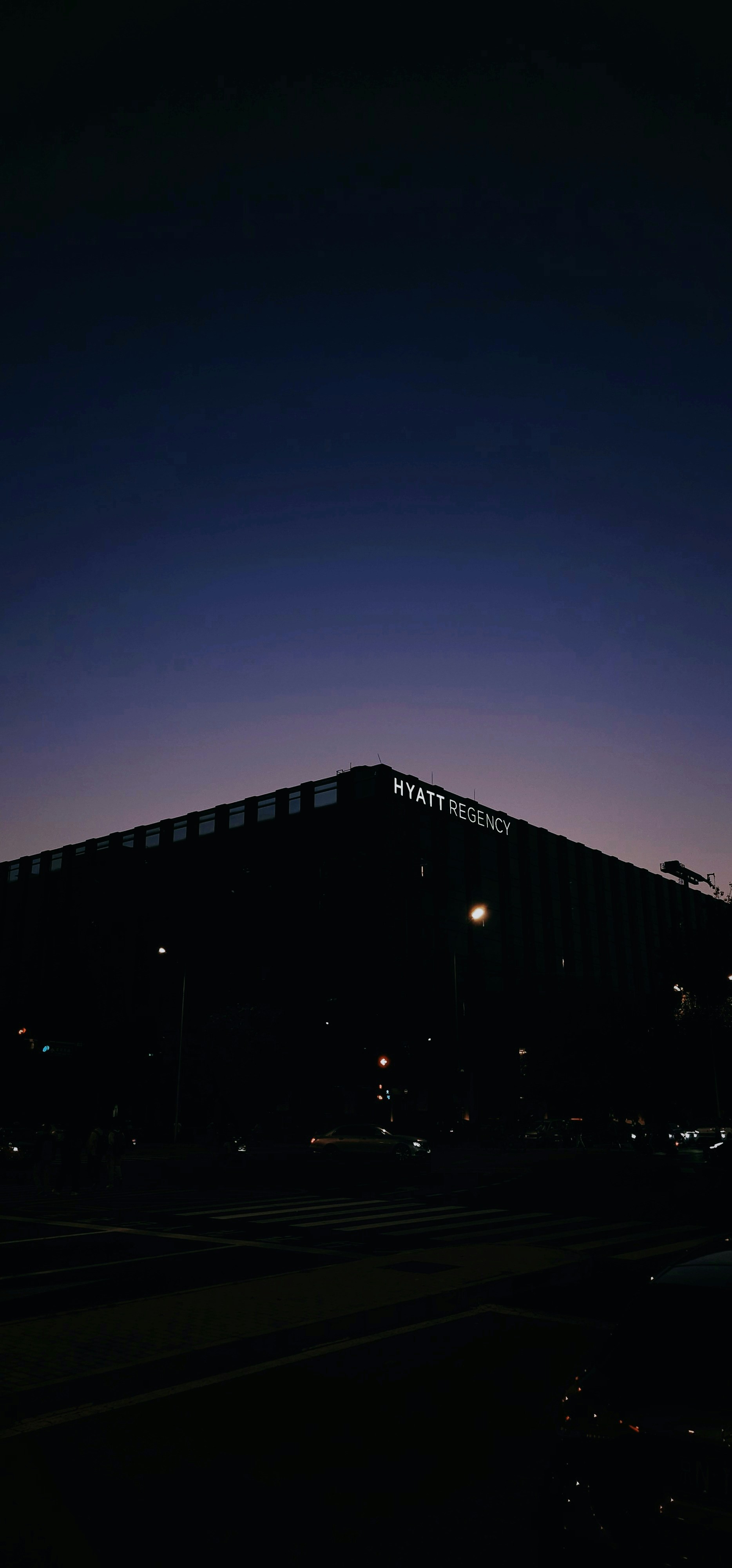 Hyatt regency building silhouetted against twilight sky