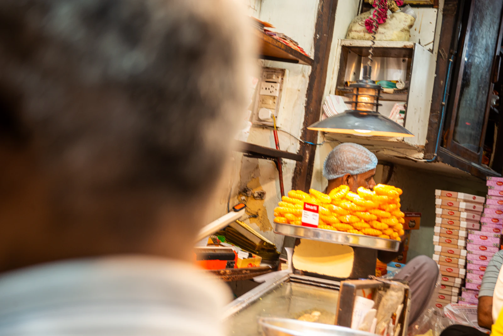 Vendor at a sweets stall serving customers