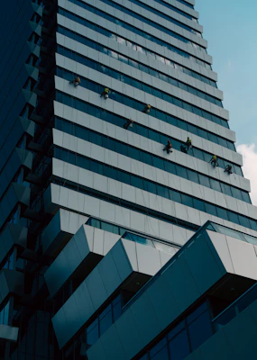 Window cleaners work on a modern skyscraper facade.
