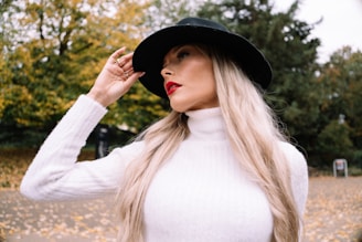 Woman in white turtleneck and black hat outdoors