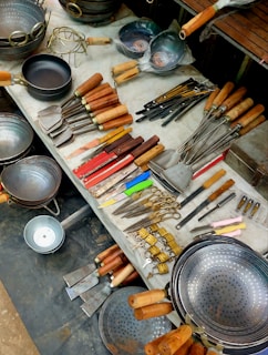 Assortment of kitchen utensils and cookware displayed on a table.