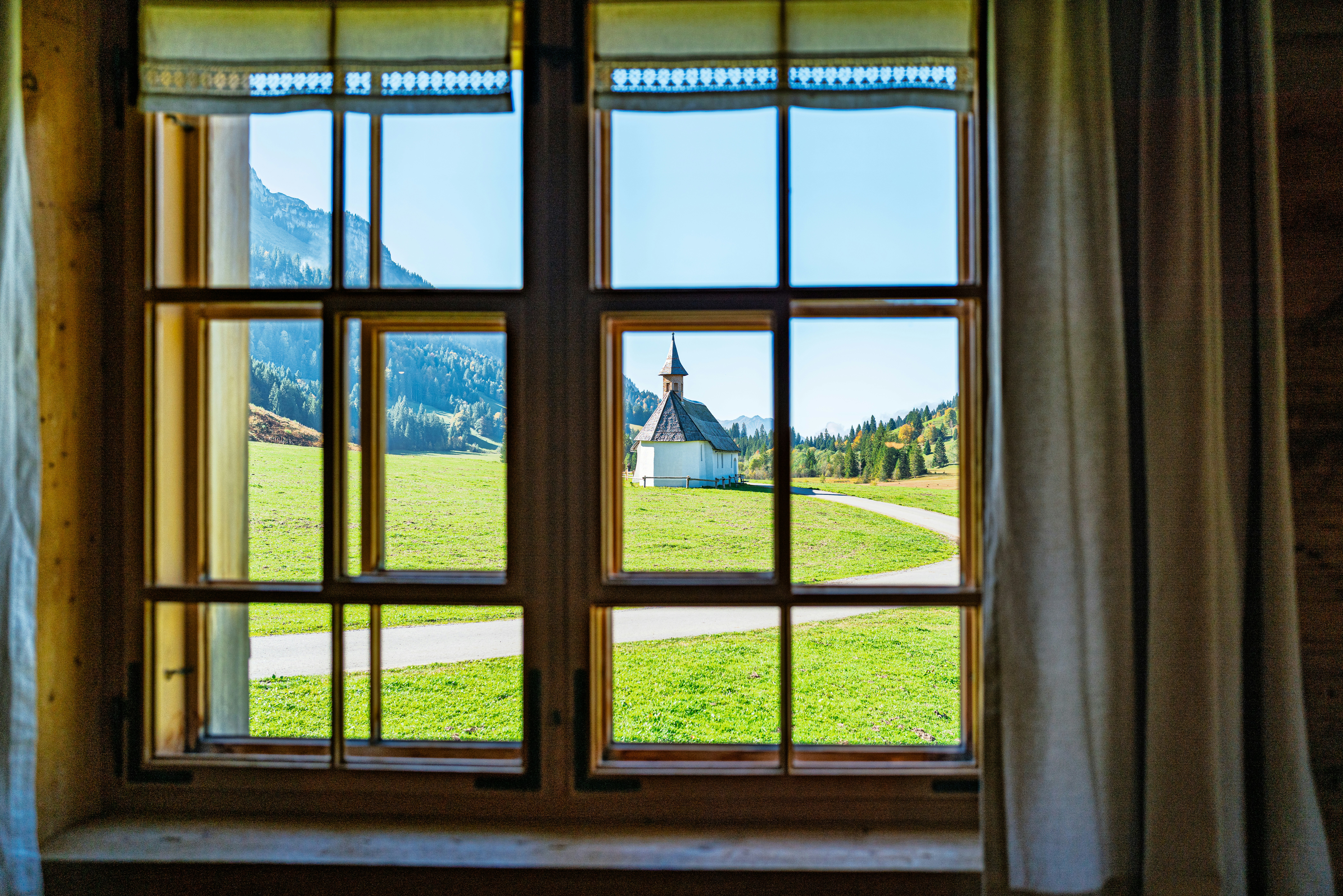 View of a small white church in a green field.