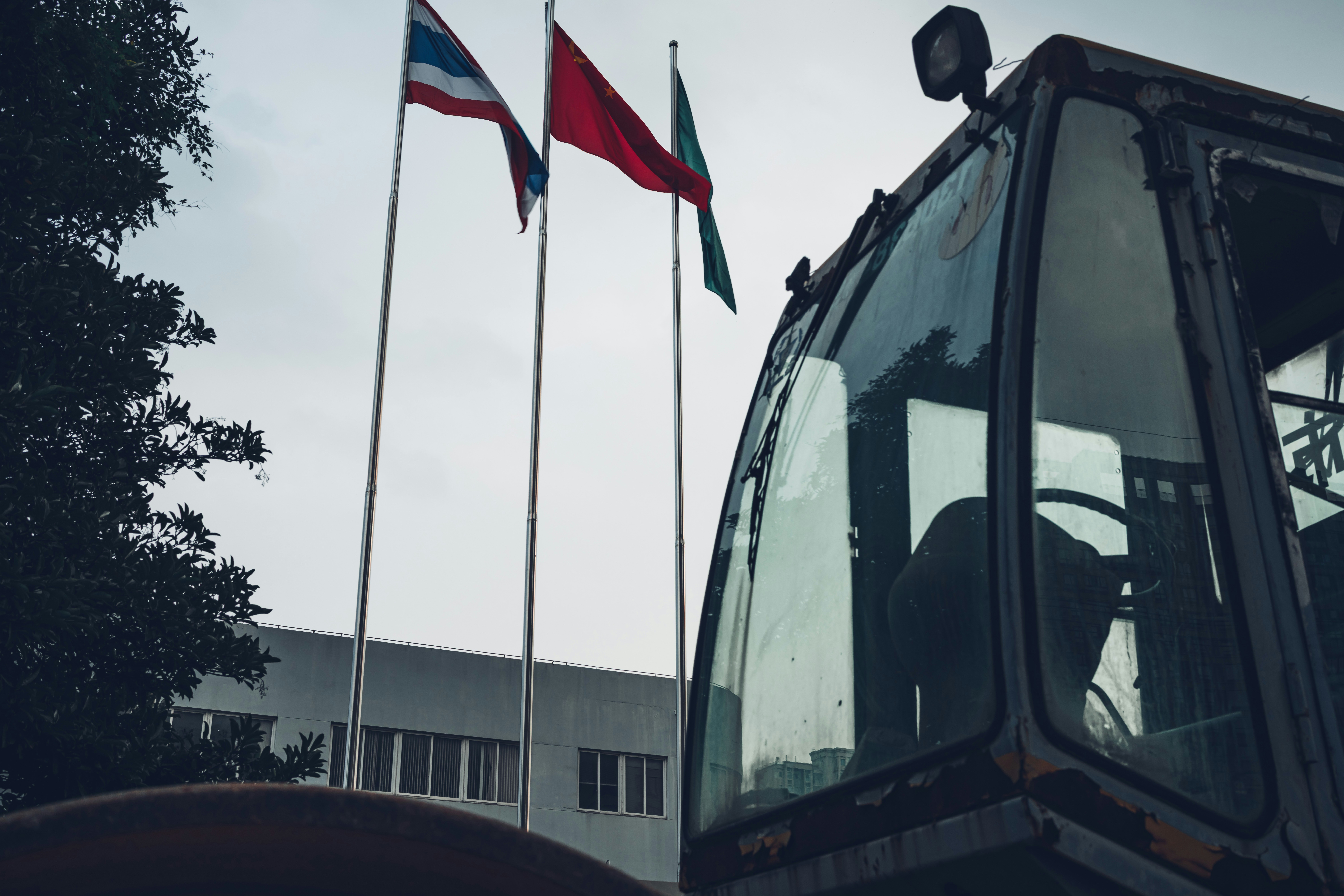 Old excavator with flags and building