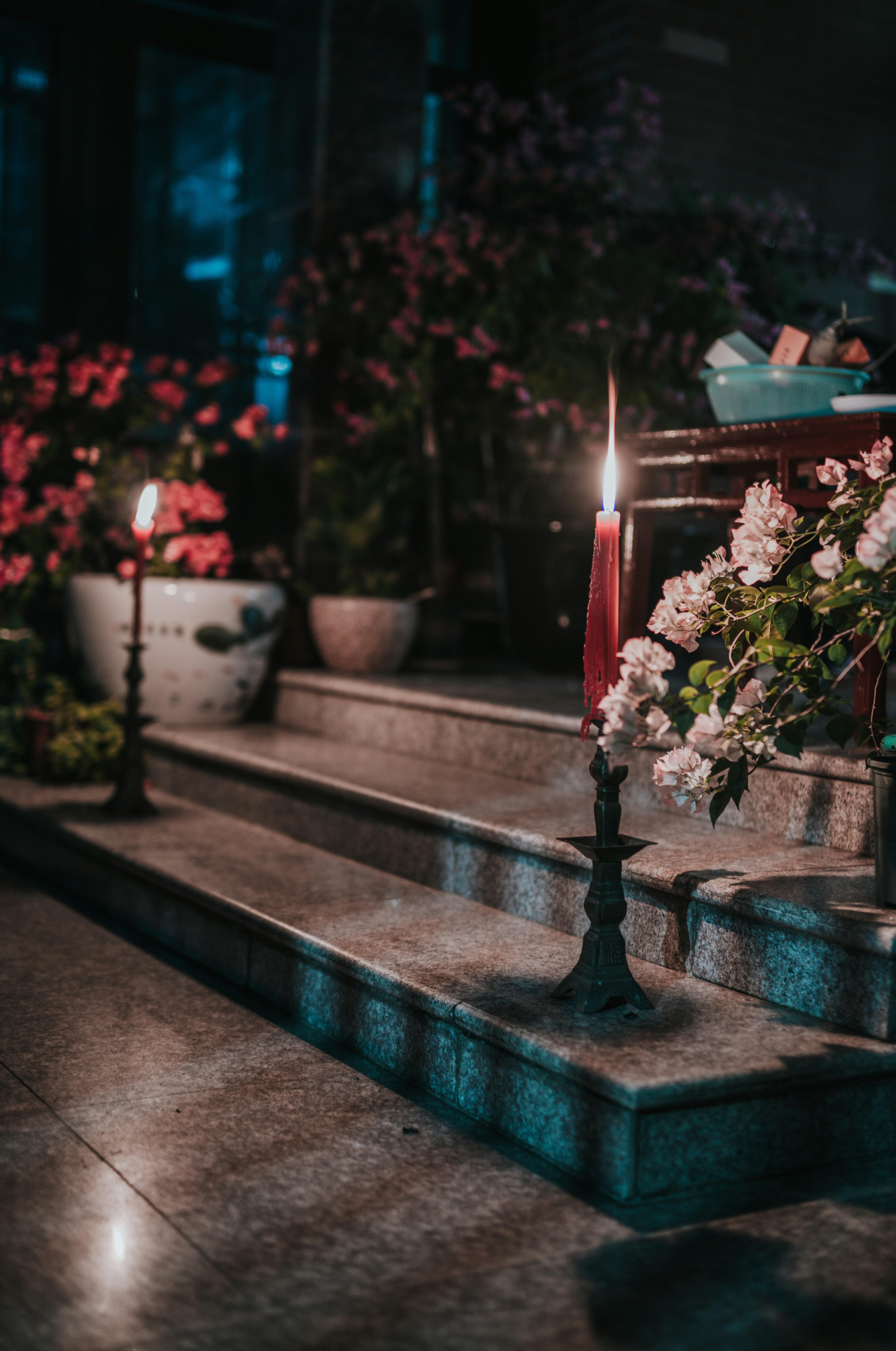 Kerzen und Blumen schmücken nachts die Stufen im Freien.