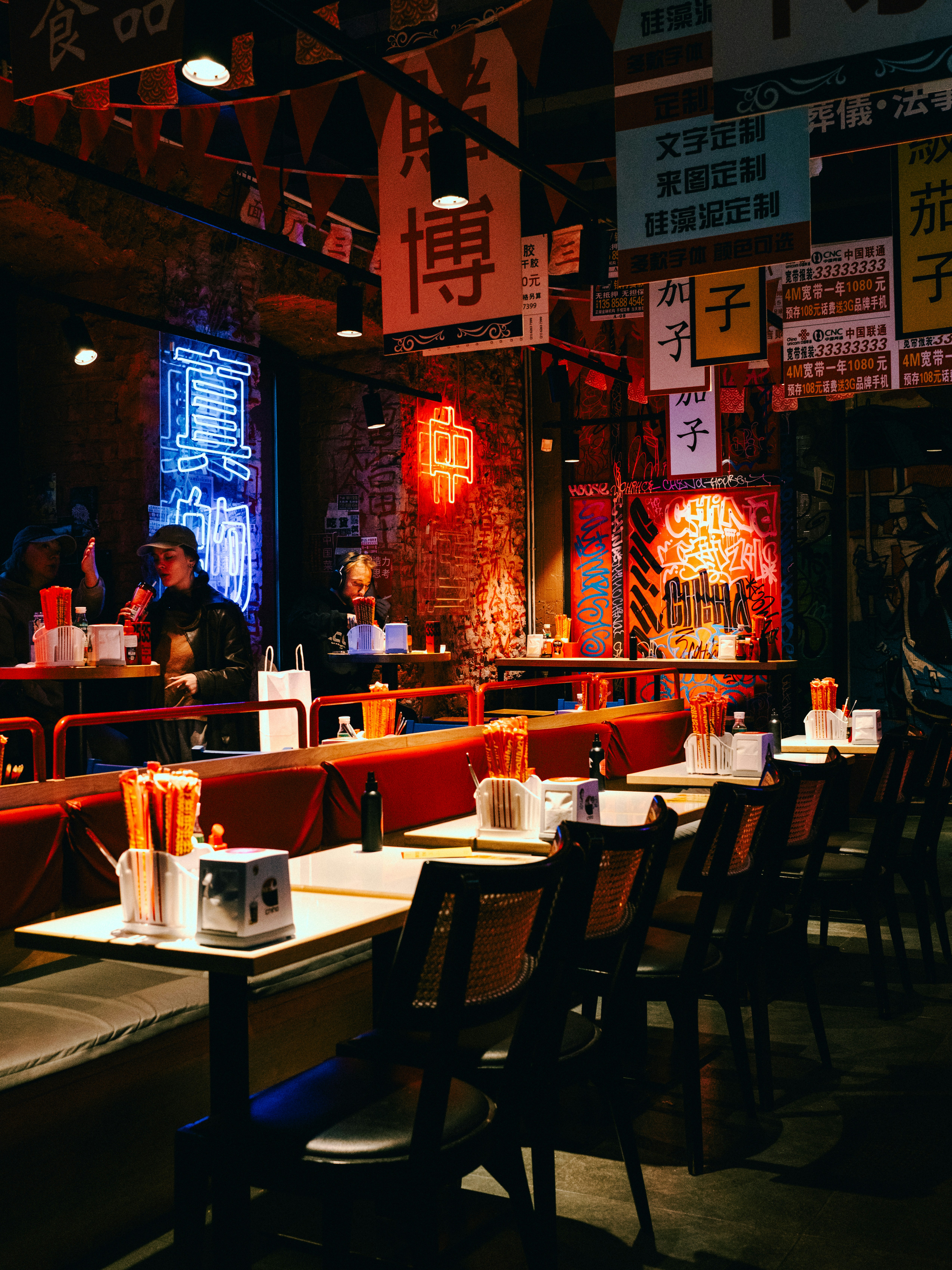 Cozy asian restaurant interior with neon signs and tables.