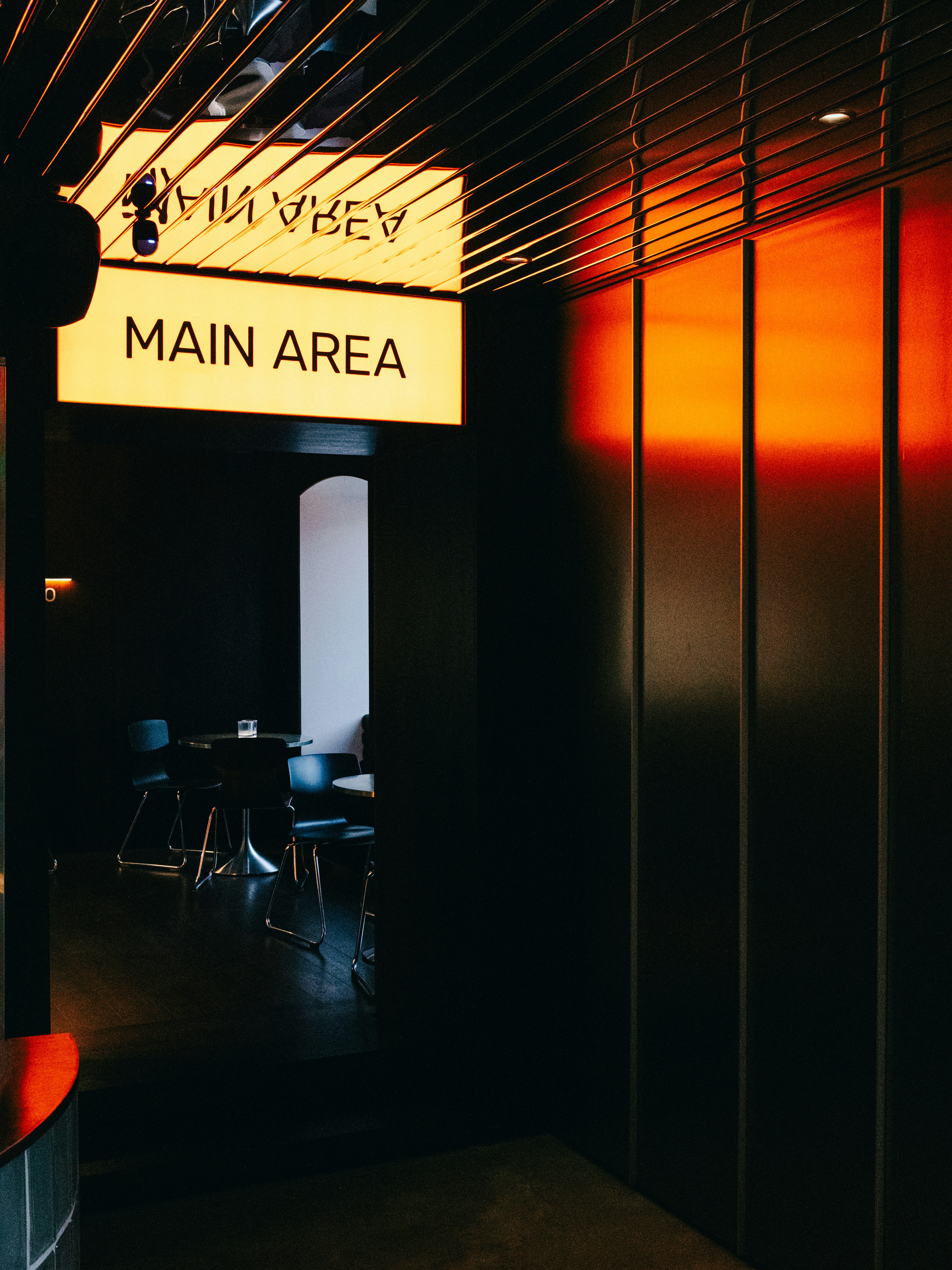 El letrero luminoso apunta hacia un área principal con poca luz.