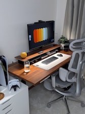 A modern desk setup with computer and gaming console.
