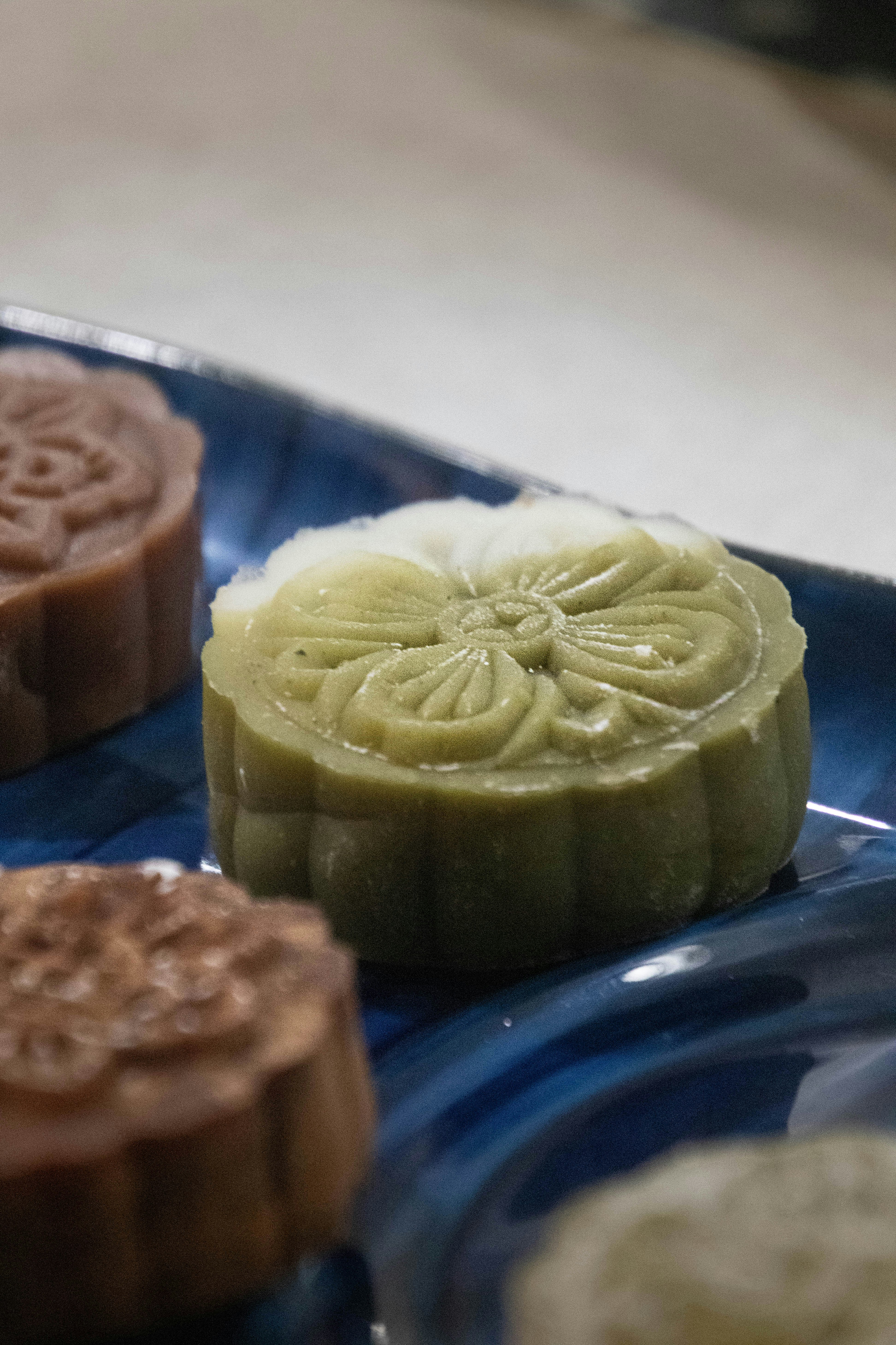 Close-up of decorative mooncakes on a blue plate.