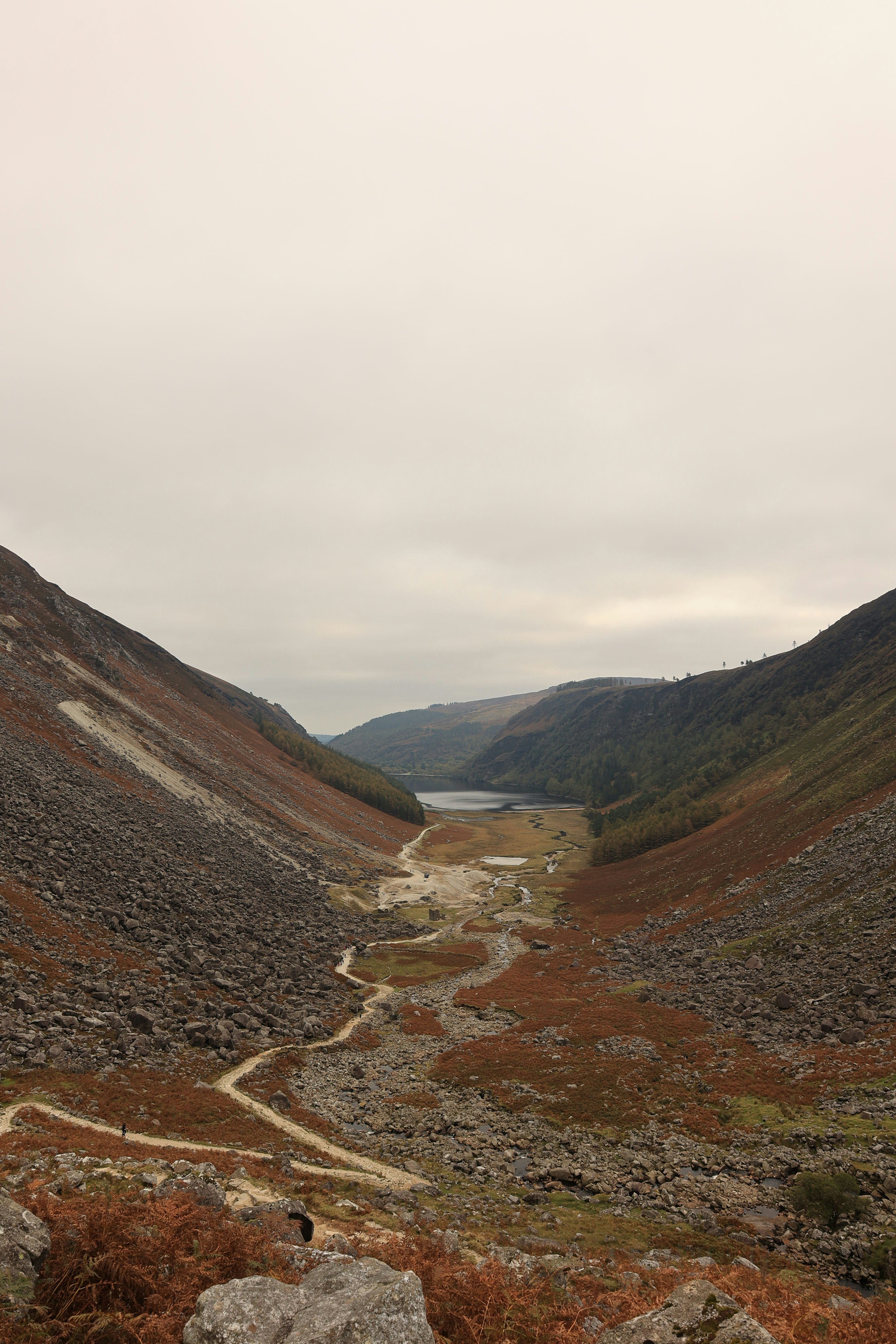 A winding path through a rocky valley towards a lake.