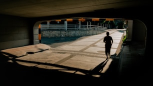 Person running through sunlit underpass path