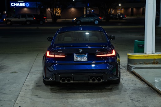 A dark blue BMW parked at night