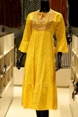 A yellow tiered dress with embroidered neckline