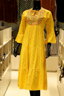 A yellow tiered dress with embroidered neckline