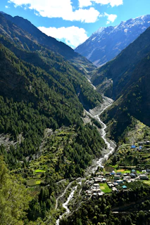 A winding river flows through a lush green mountain valley.