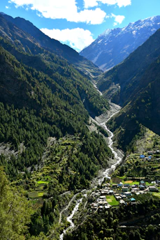 A winding river flows through a lush green mountain valley.