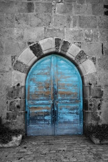 An old weathered blue door in stone wall