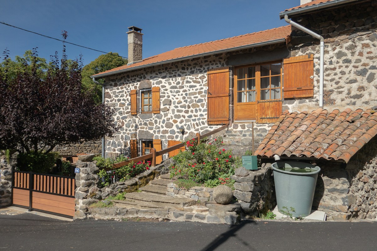 Maison en pierre à volets de bois dans un village français - Guardiens