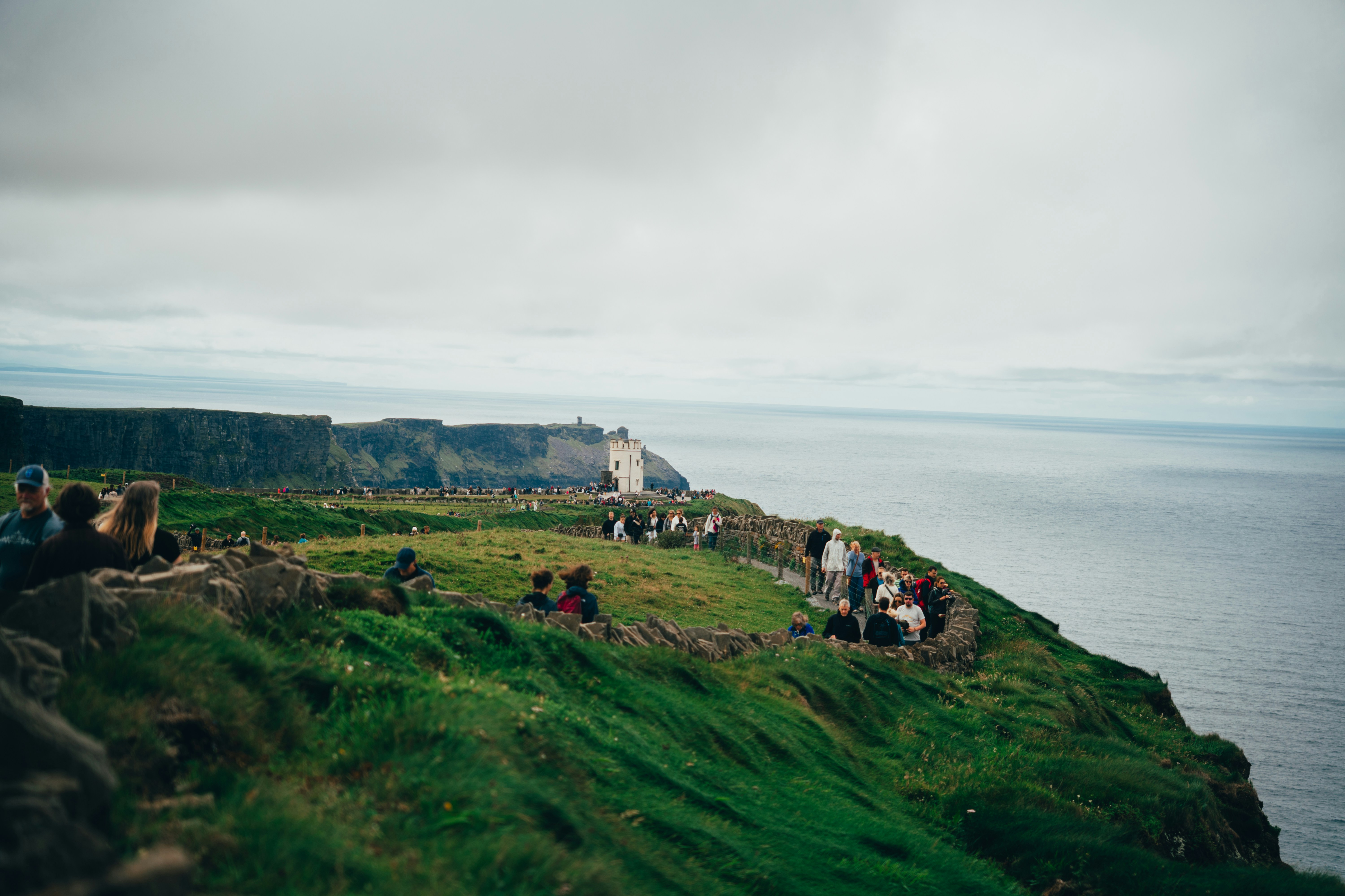 People admire the cliffs overlooking the ocean