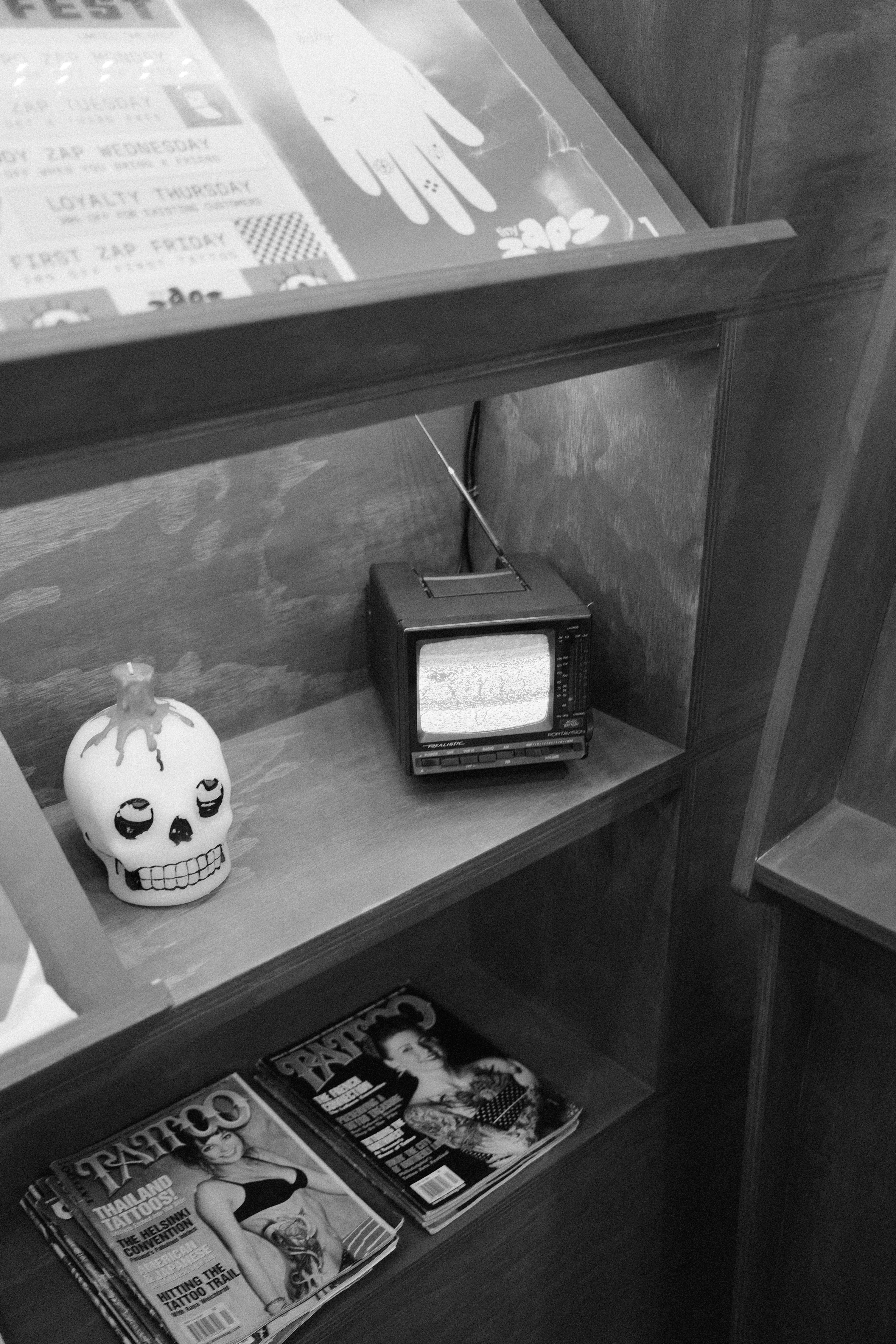 Small television and skull decoration on shelf
