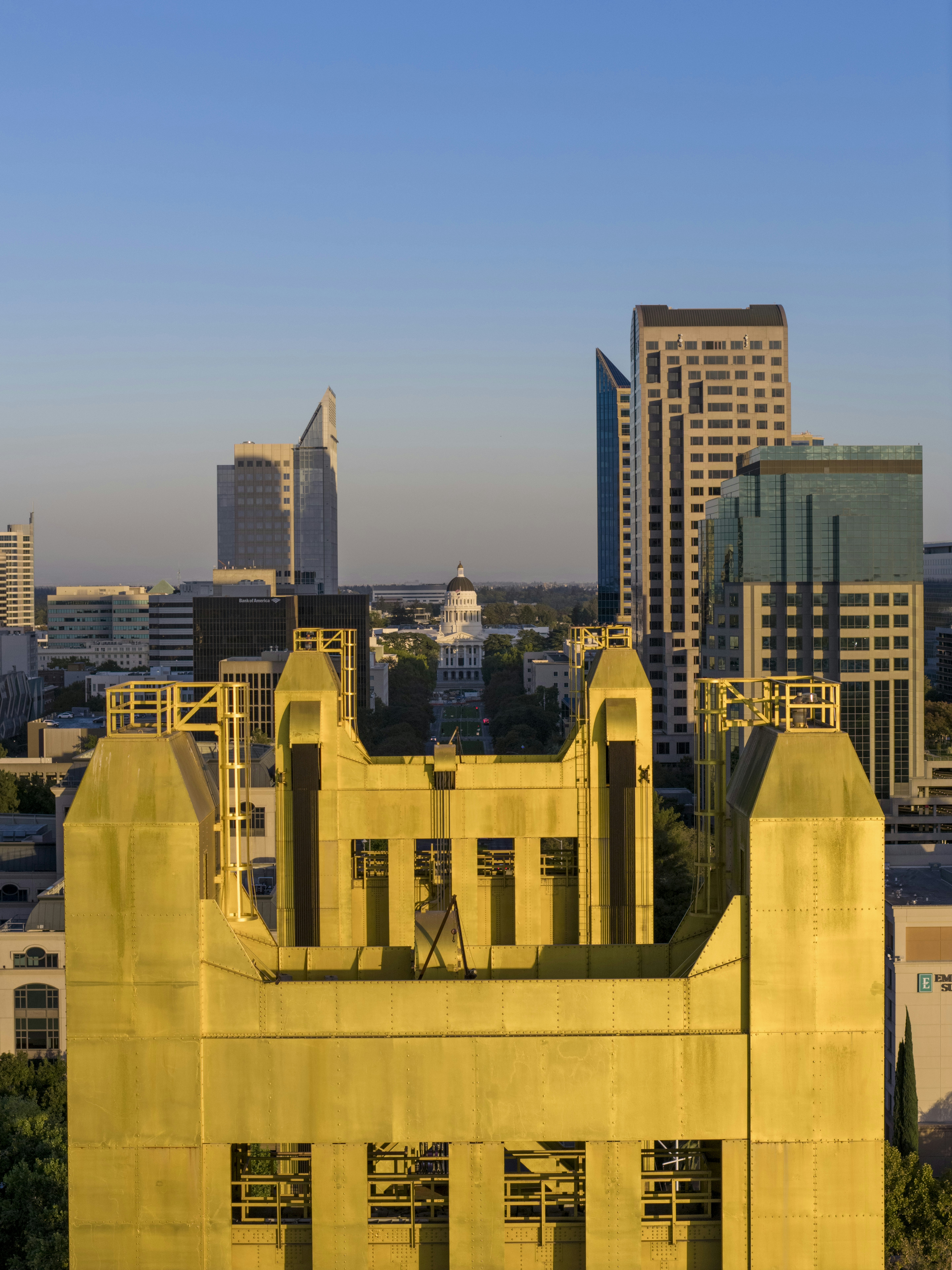Golden tower with city skyline and capitol building.