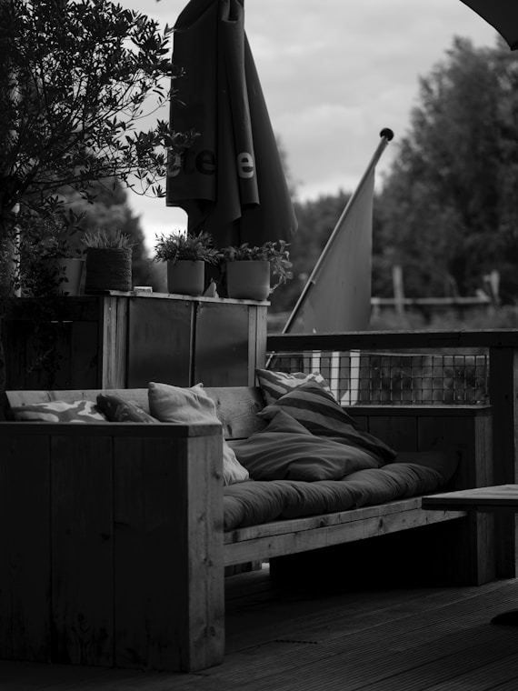 Wooden outdoor sofa with cushions and umbrella