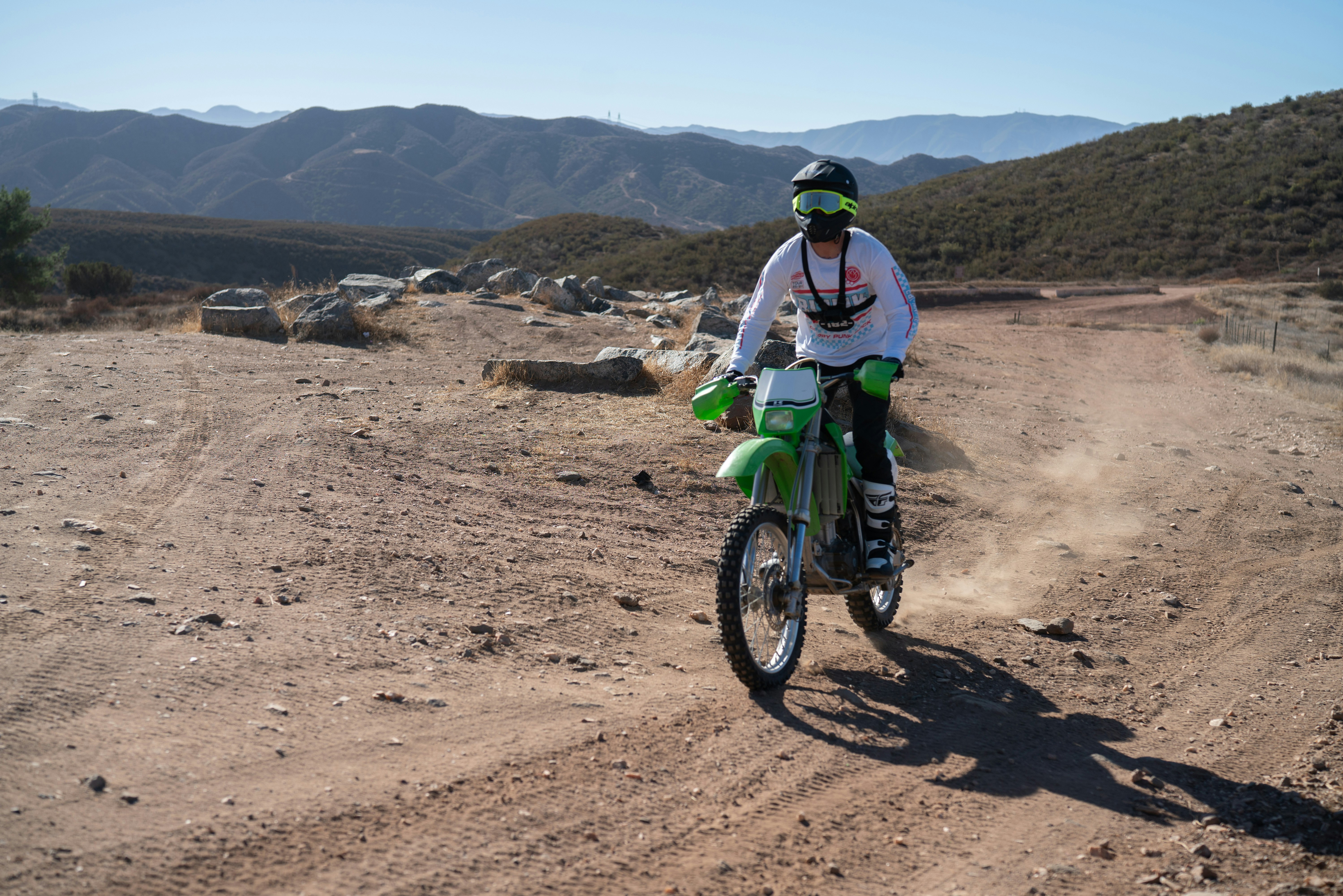Uma pessoa anda de bicicleta suja em uma trilha empoeirada.