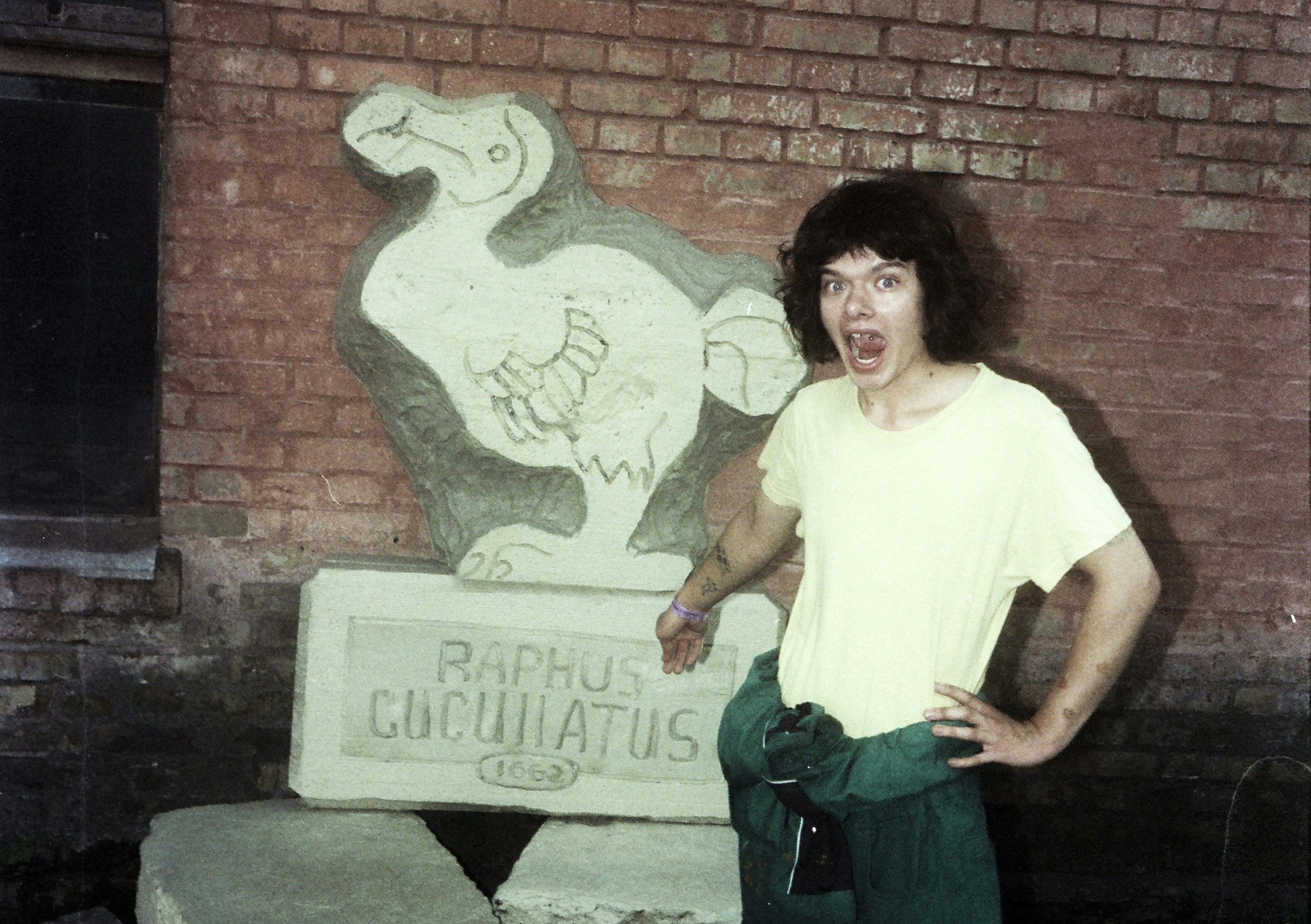 Man standing next to a dodo bird sculpture