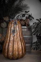 A decorative metallic pumpkin with ornate stem and leaves.