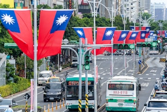 Numerous taiwanese flags line a busy city street.