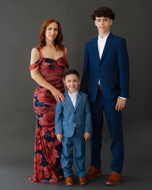 A woman and two boys in suits