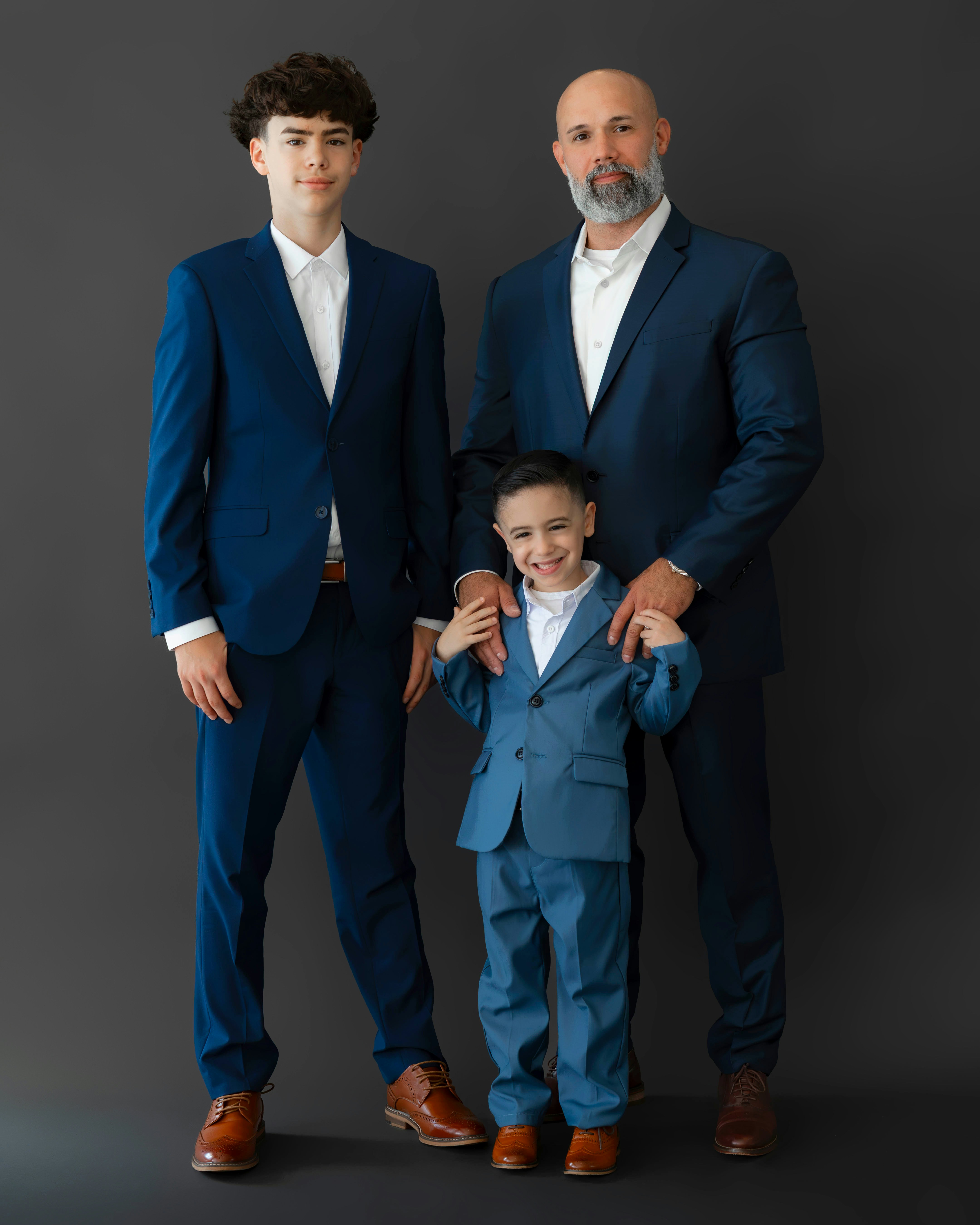 Father and two sons in matching blue suits.