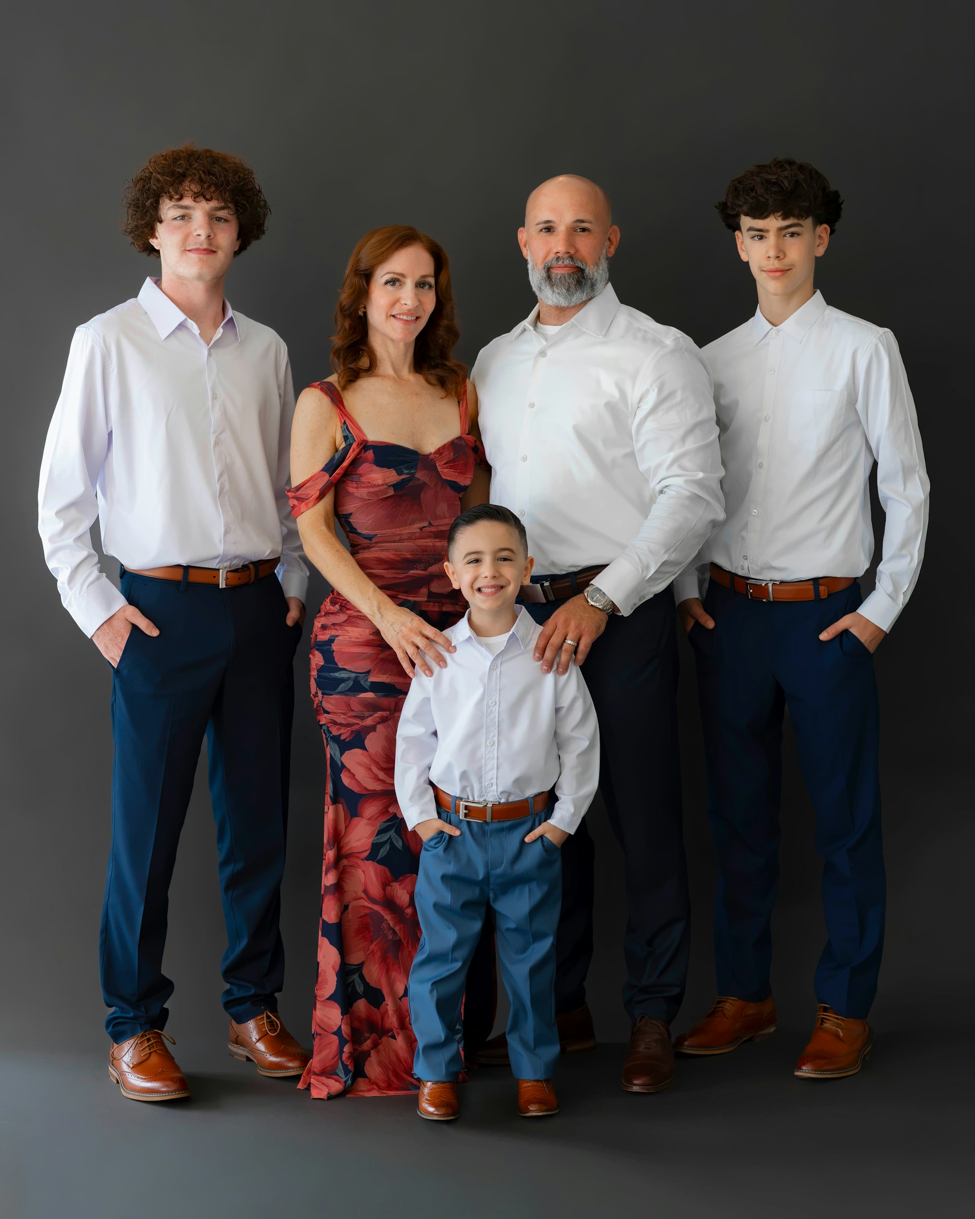 Family of five posing for a studio portrait.