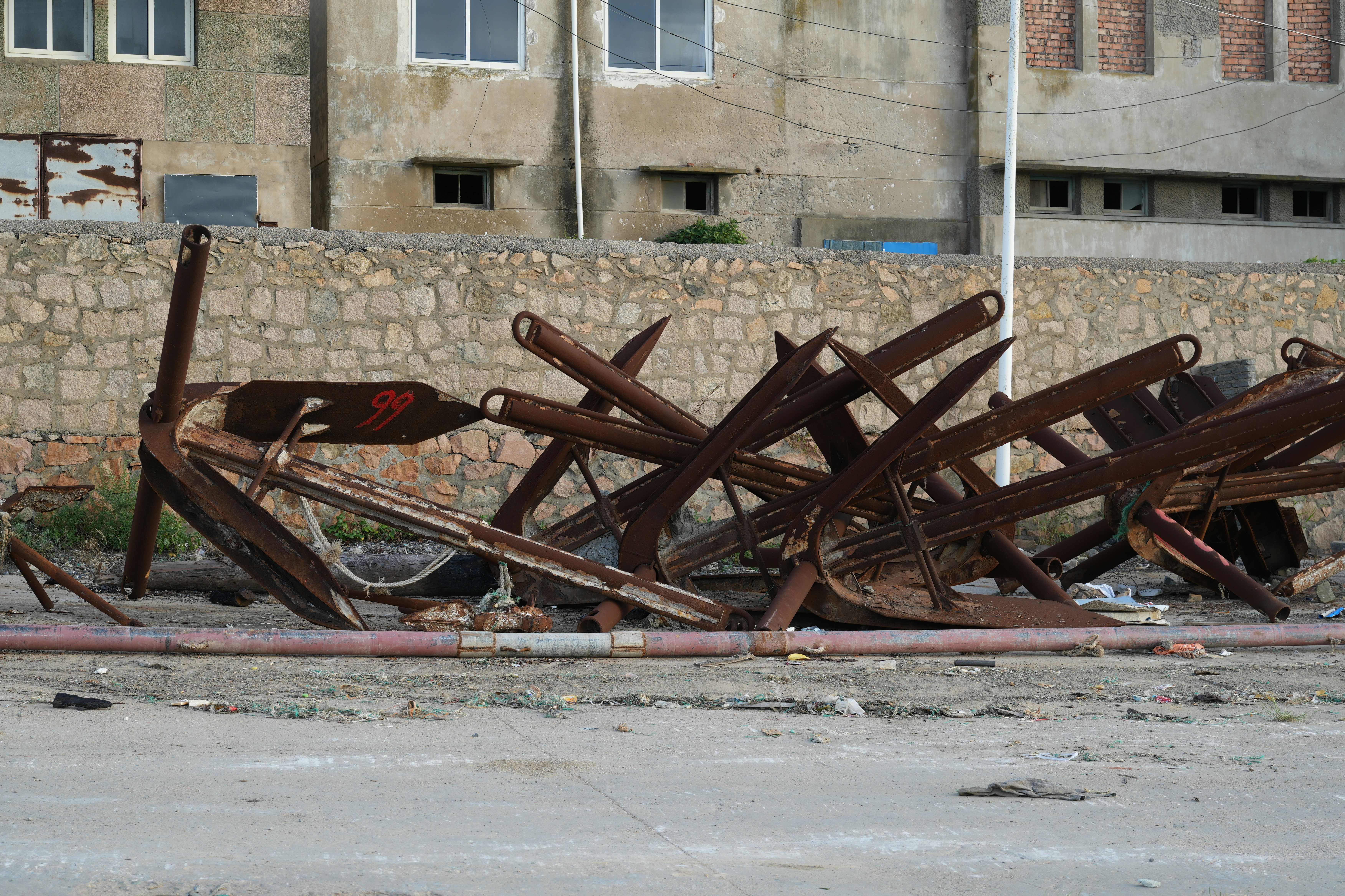 Pile of rusty ship anchors on the ground