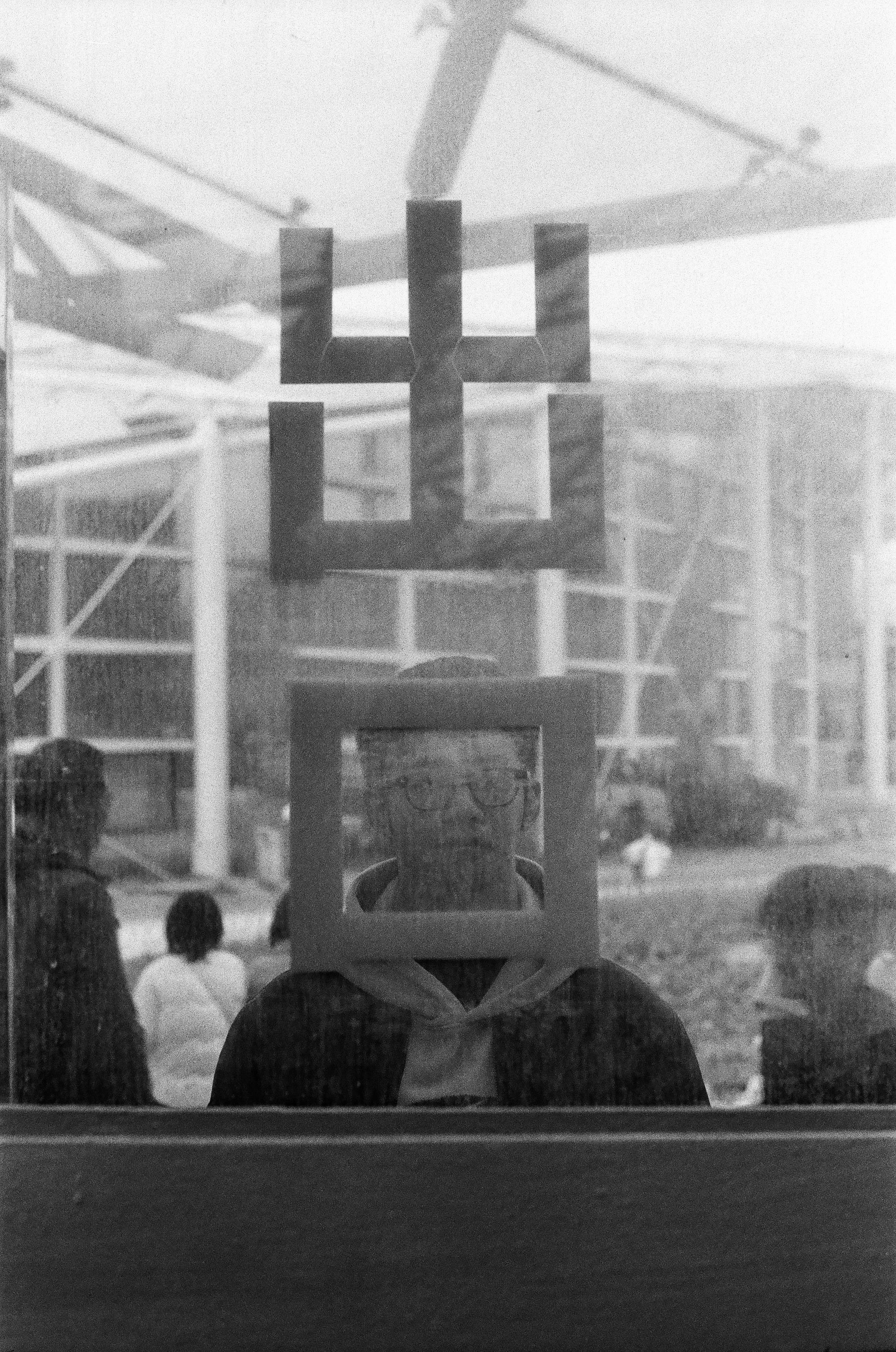 Man reflected in glass with square frame