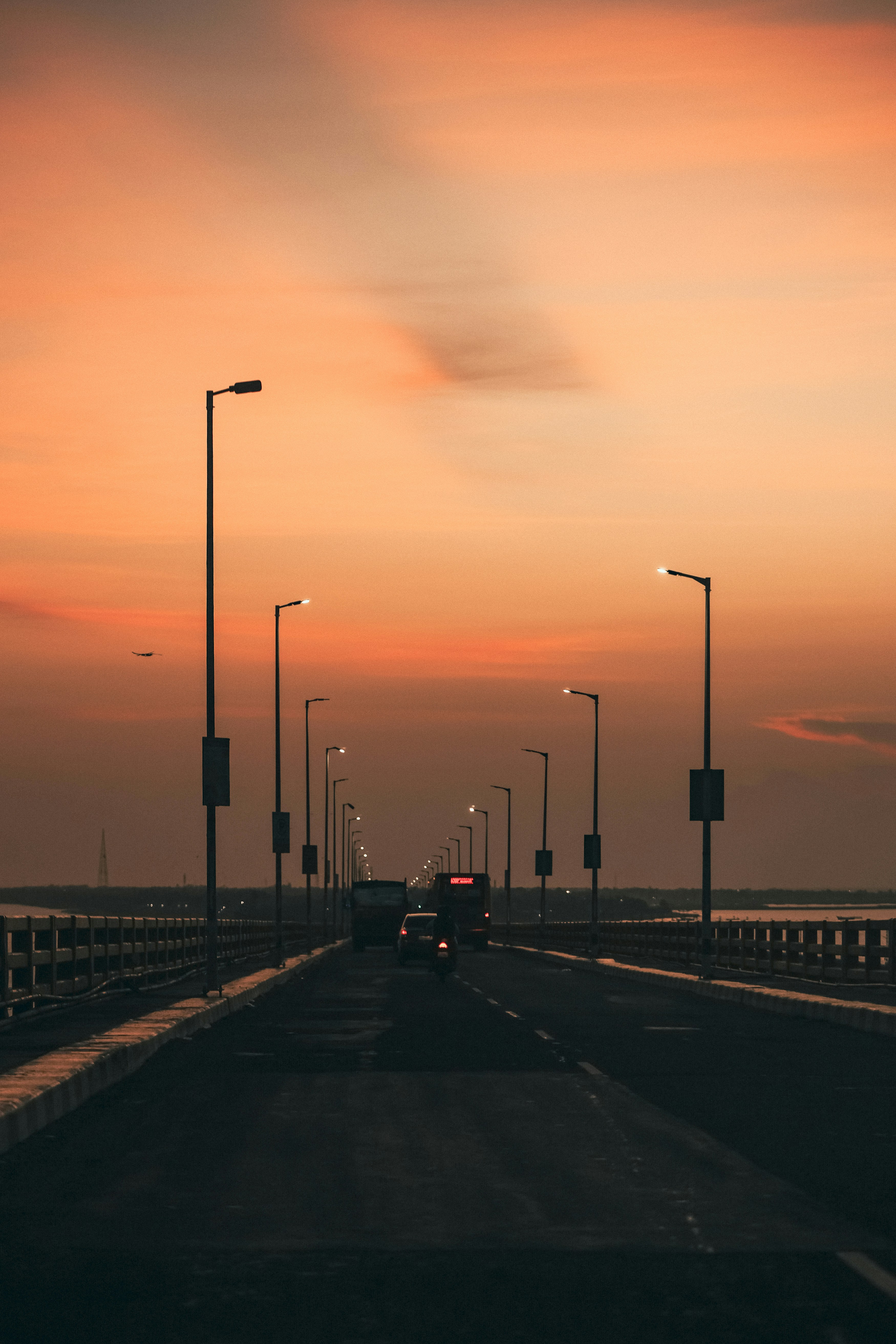 Vehicles on a bridge at sunset