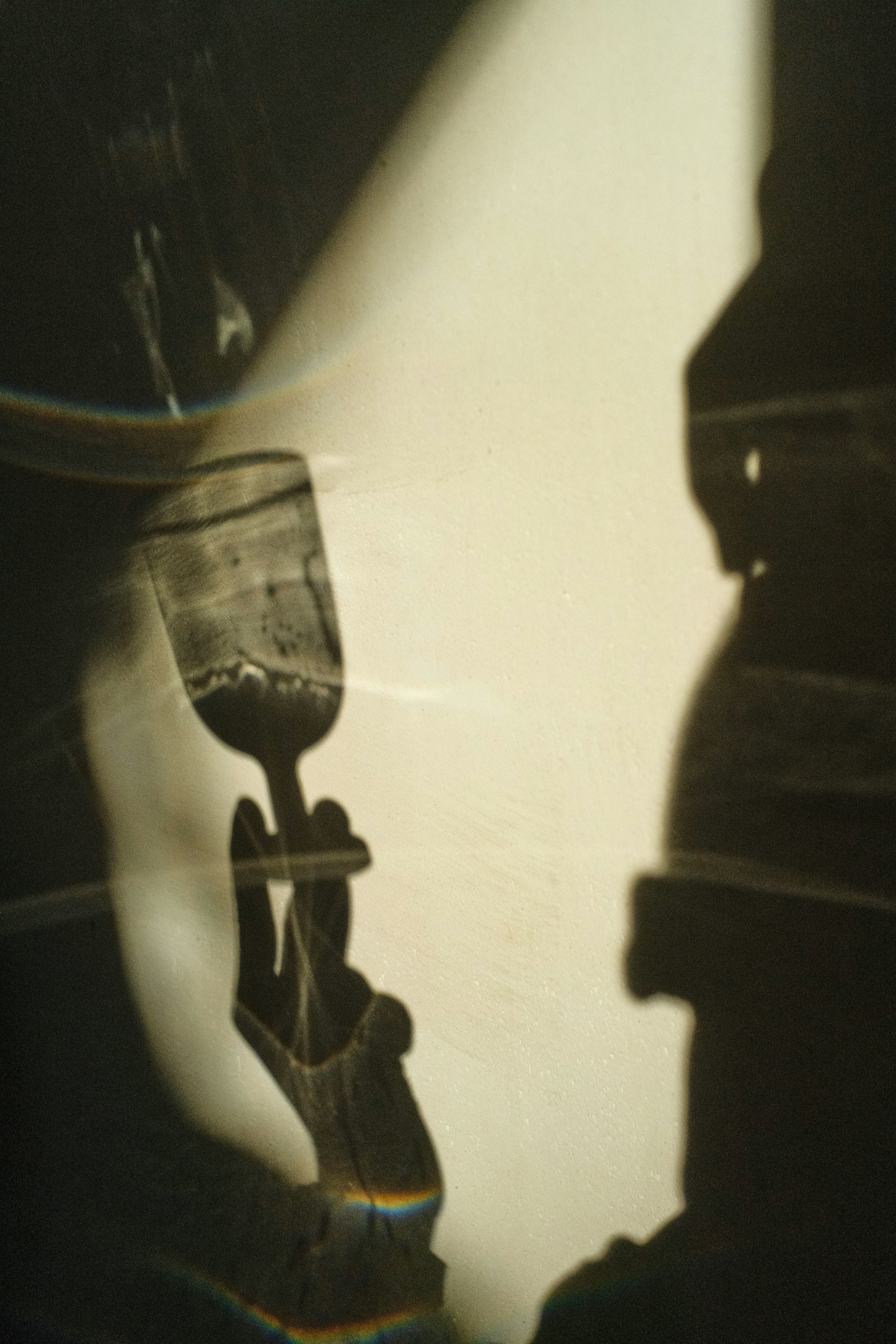 Shadows of a hand holding a glass with liquid.