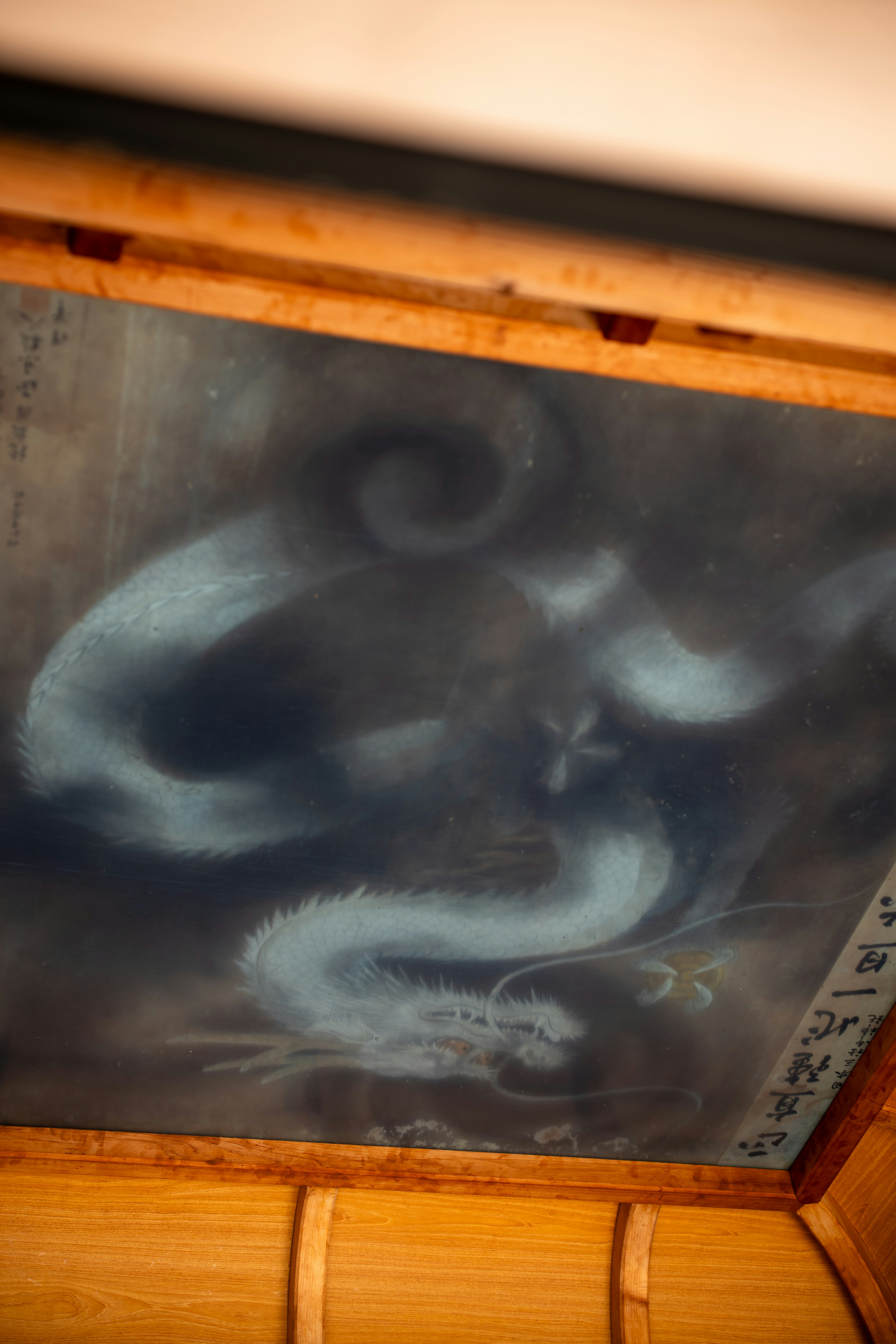 Une peinture d’un dragon blanc sur un fond sombre.