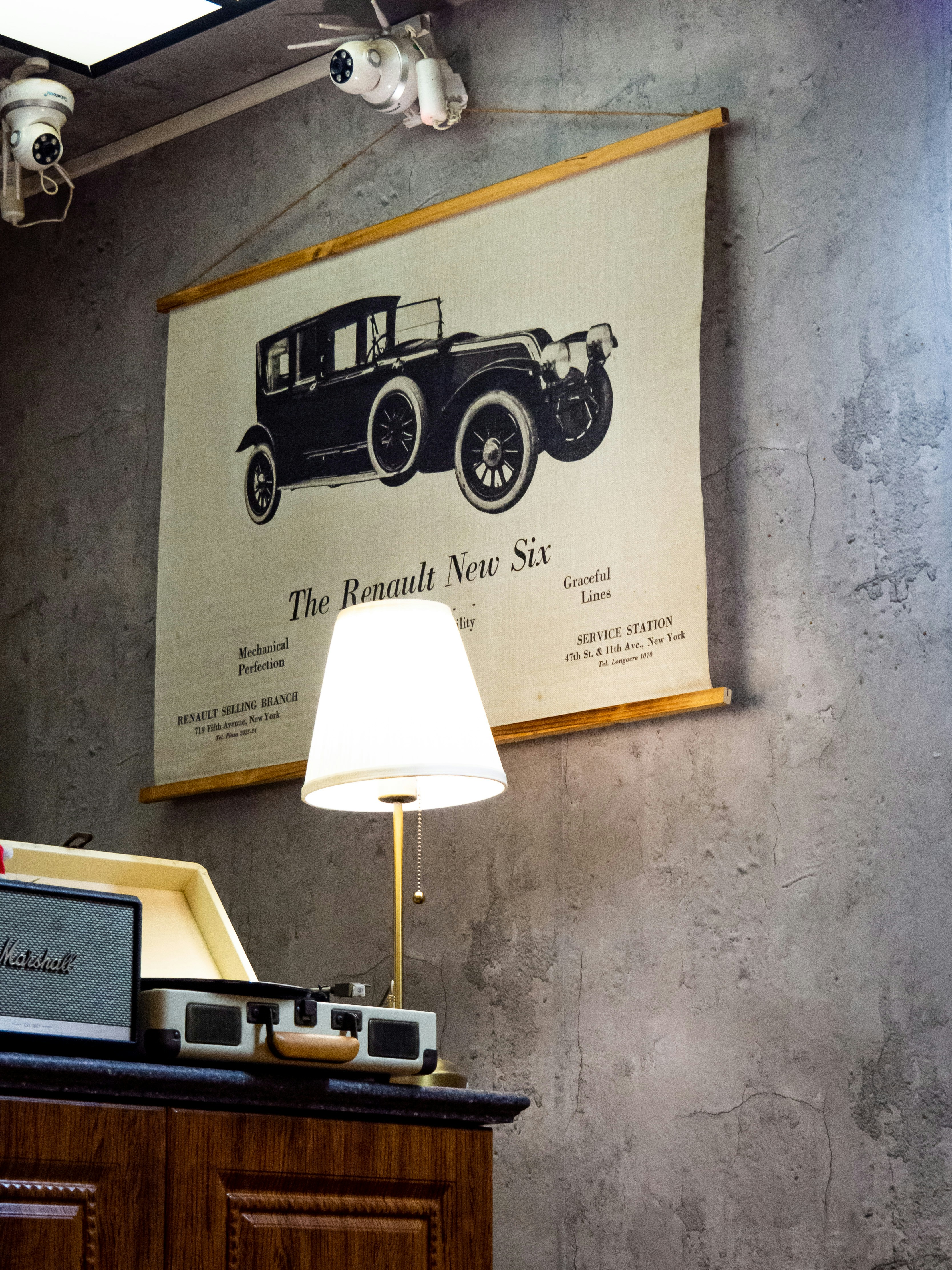 Vintage car poster above a lamp and lamp.