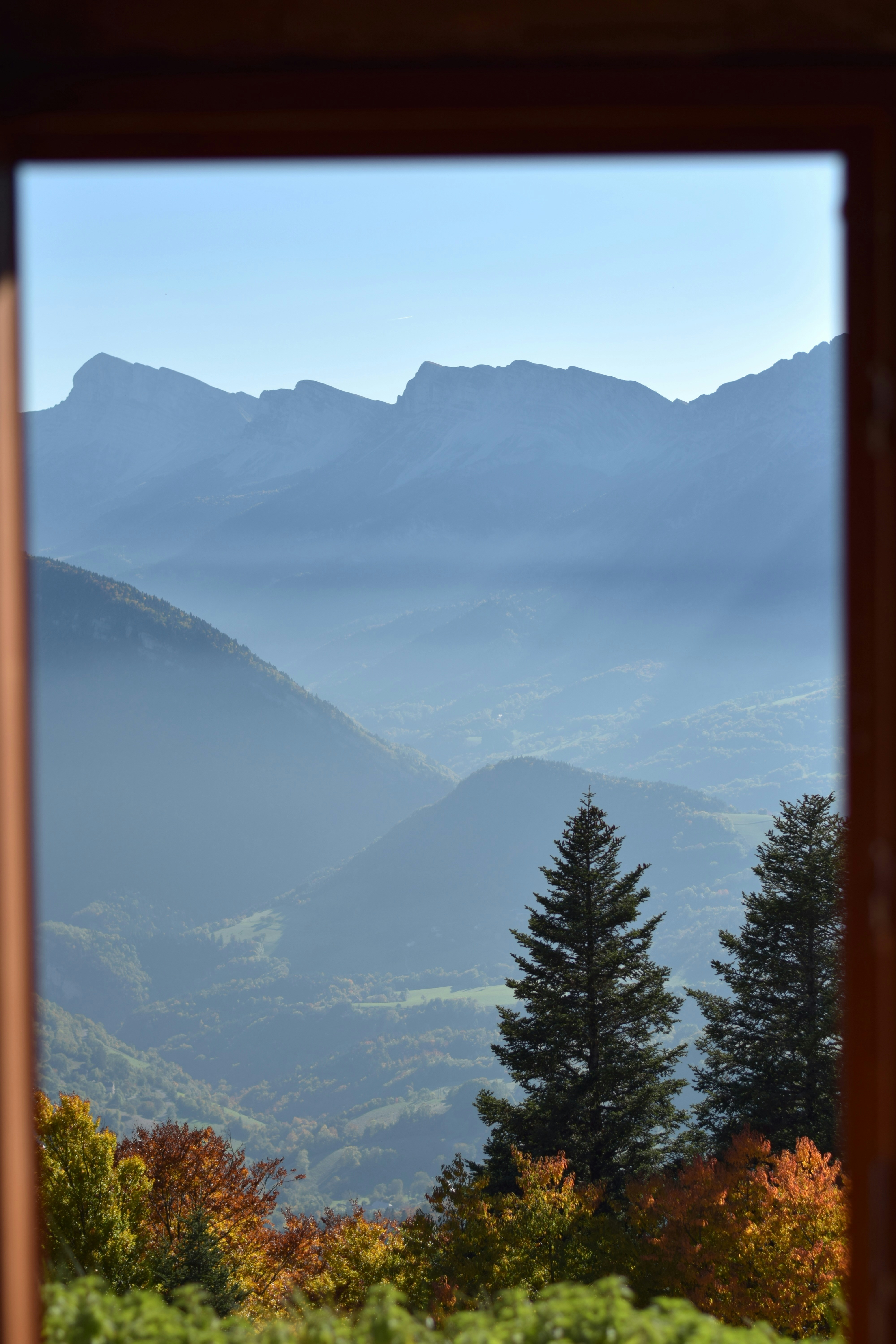 유리틀 너머로 보이는 안개 낀 산의 풍경.