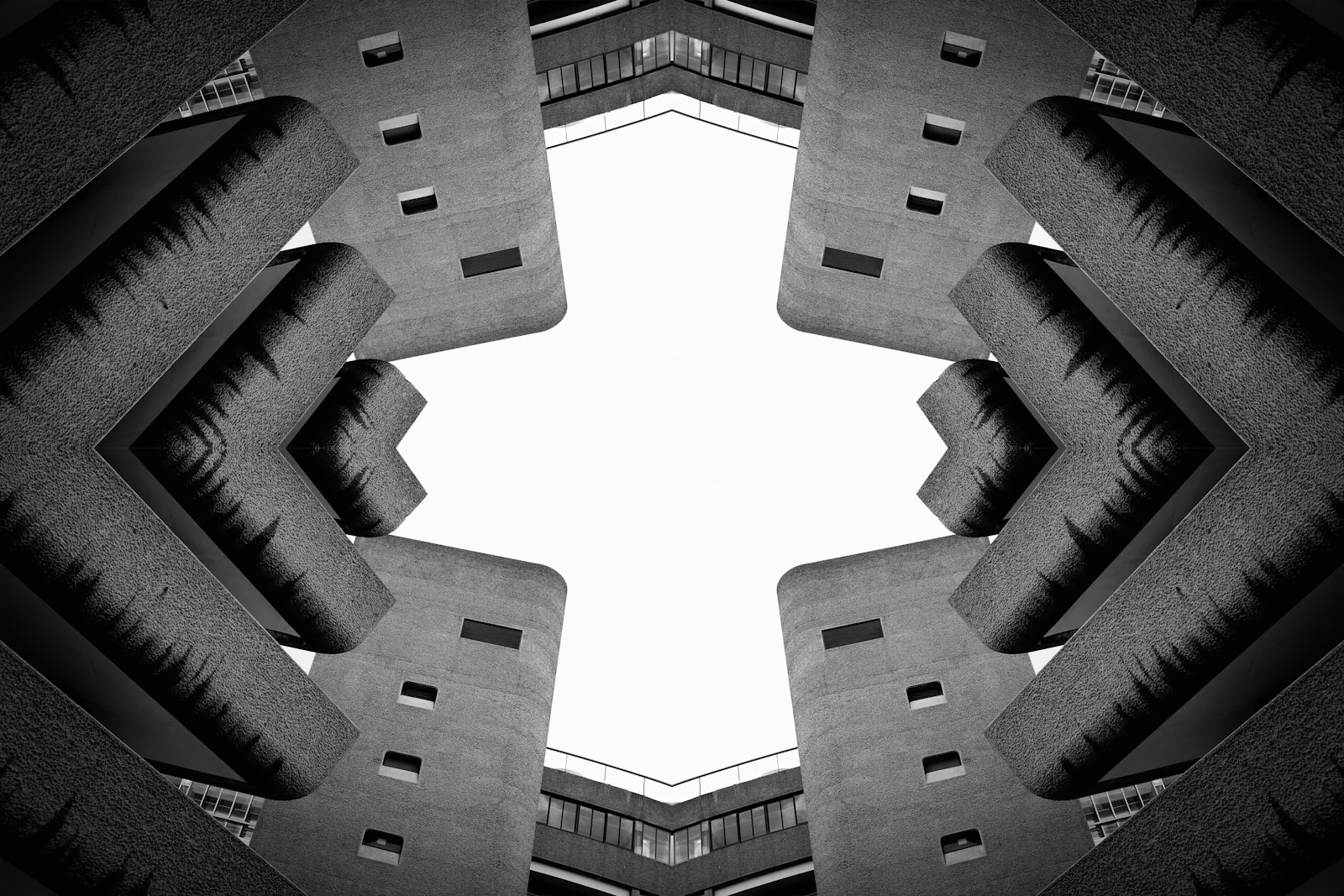 Symmetrical concrete towers of a brutalist building looming against an overcast sky