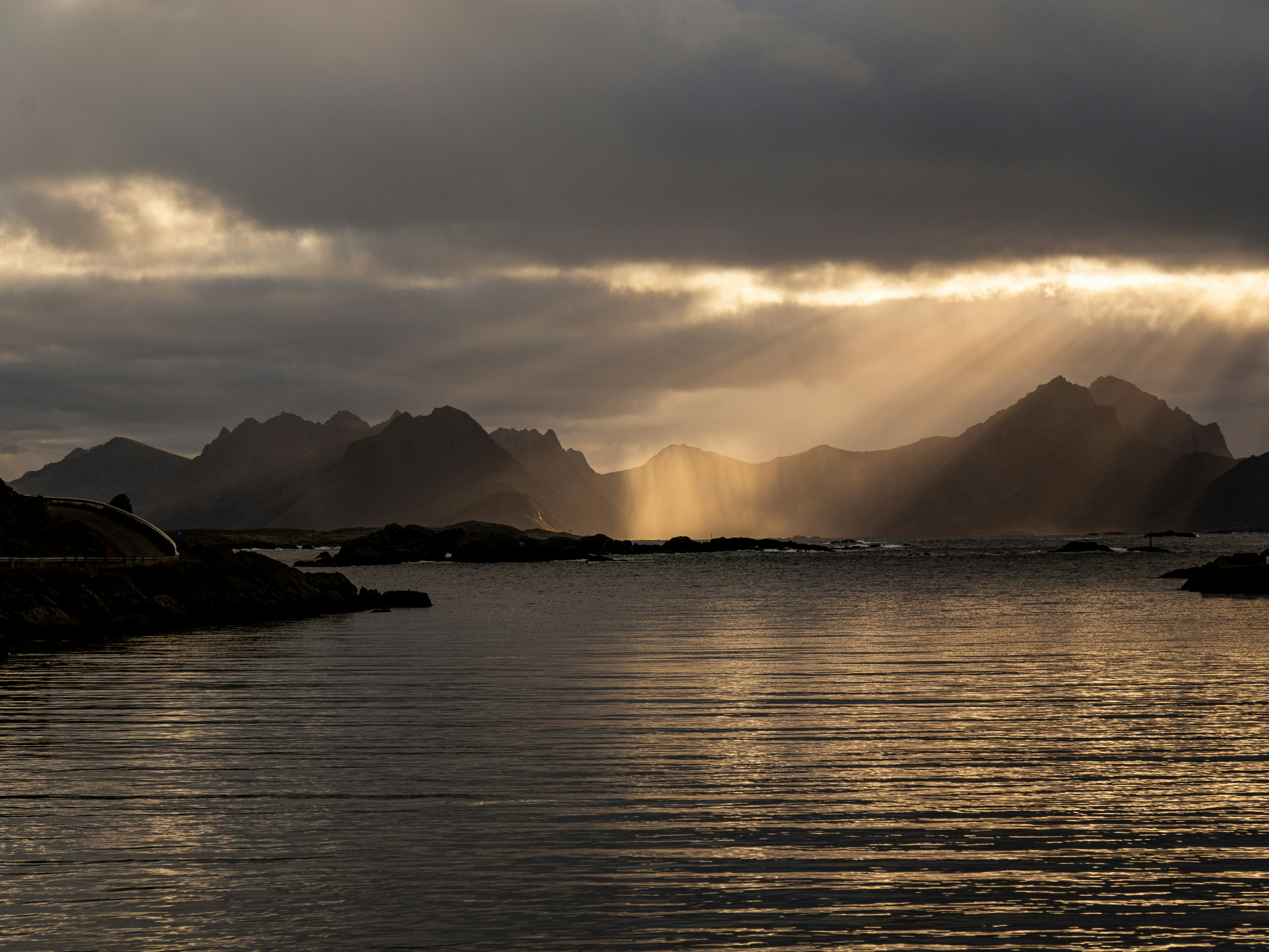 Sunbeams break through clouds over rocky coastline
