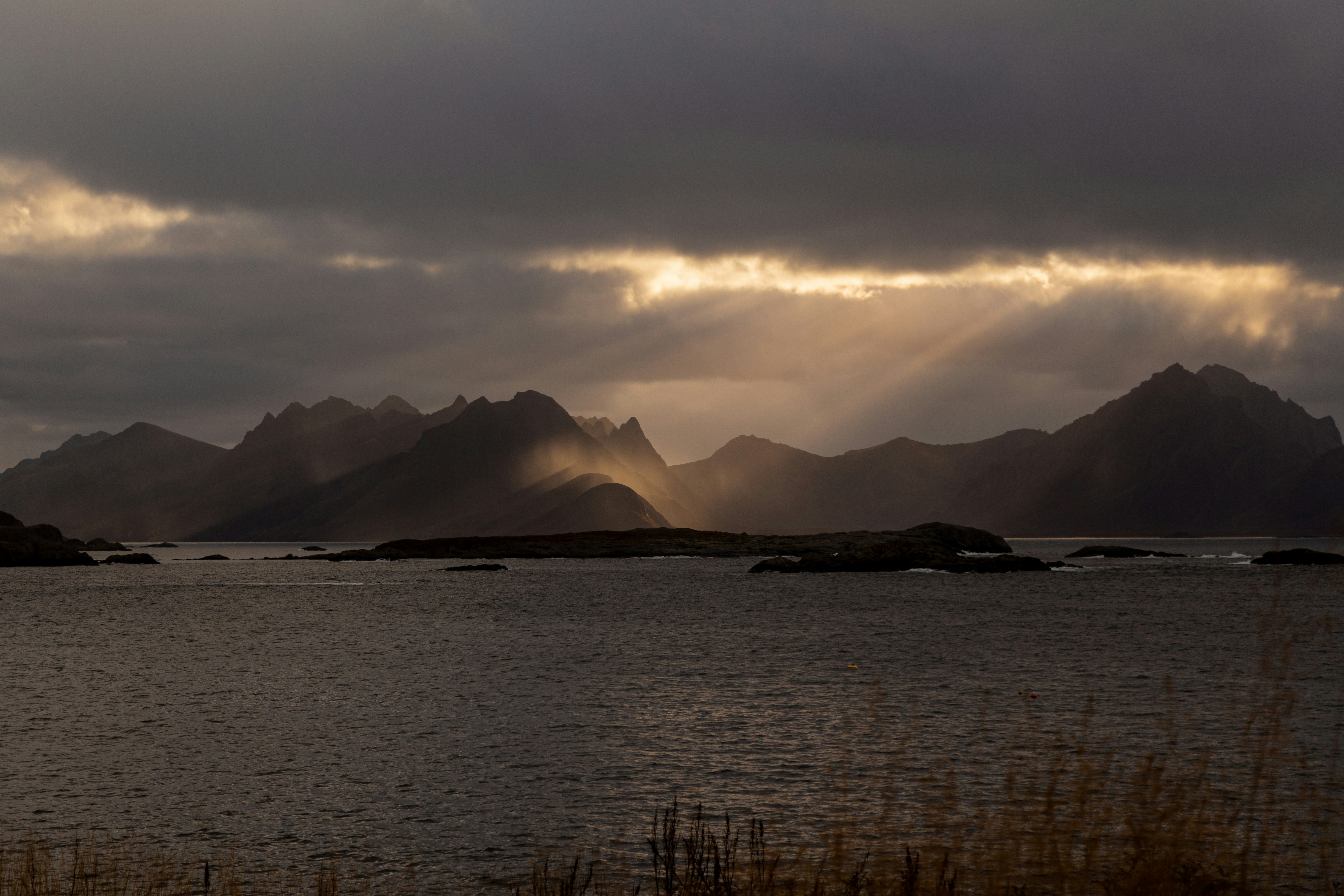 Sunbeams breaking through dramatic clouds over mountains