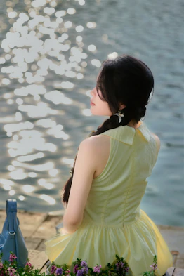 Woman in yellow dress by sparkling water