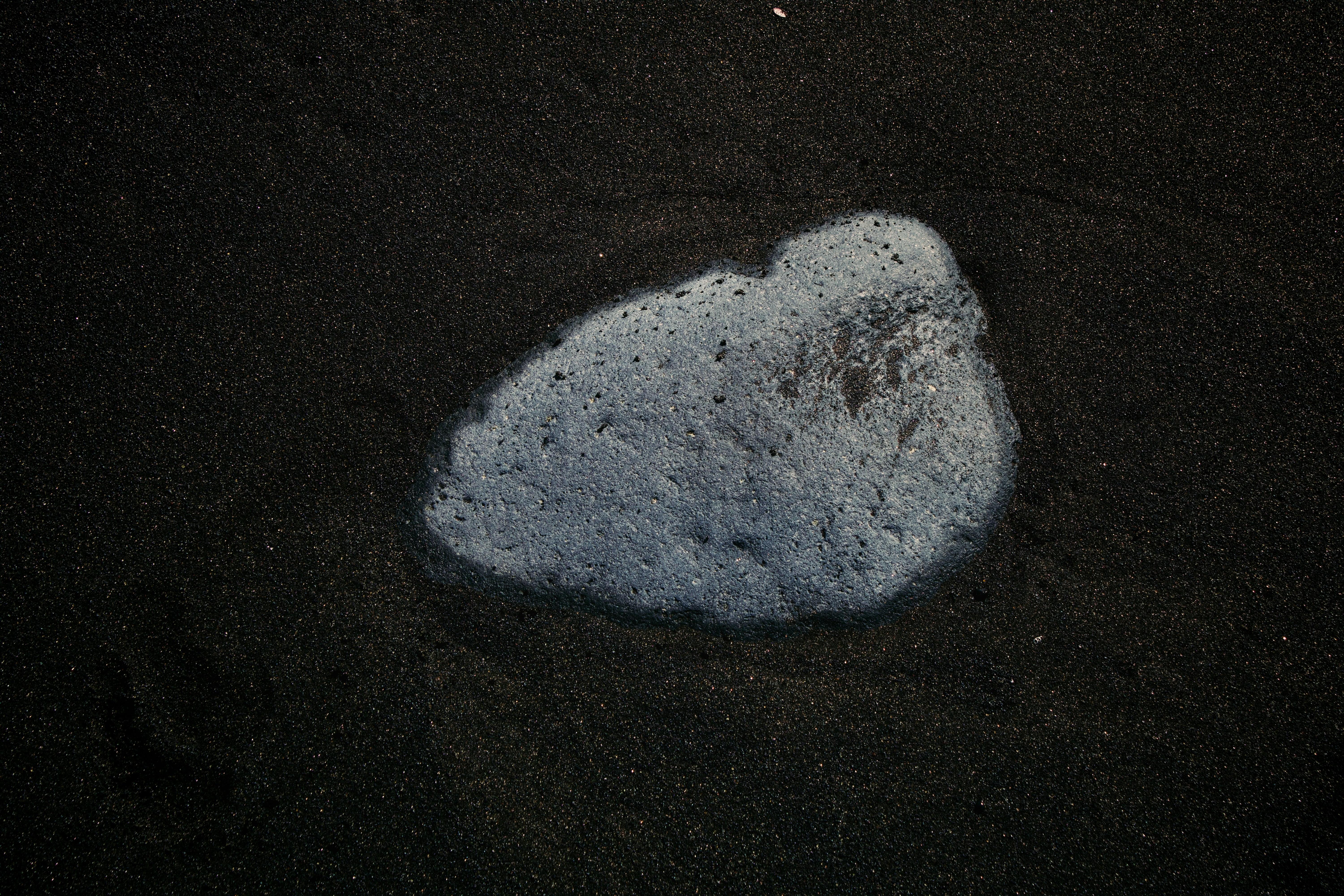 A foamy substance on dark sand