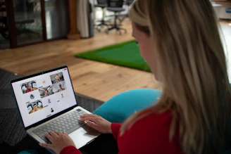 Woman using a laptop with video conference on screen