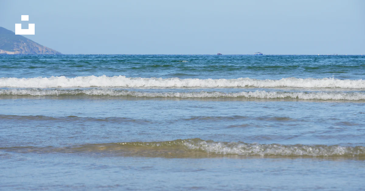Les douces vagues de l’océan roulent sur un rivage sablonneux. photo ...
