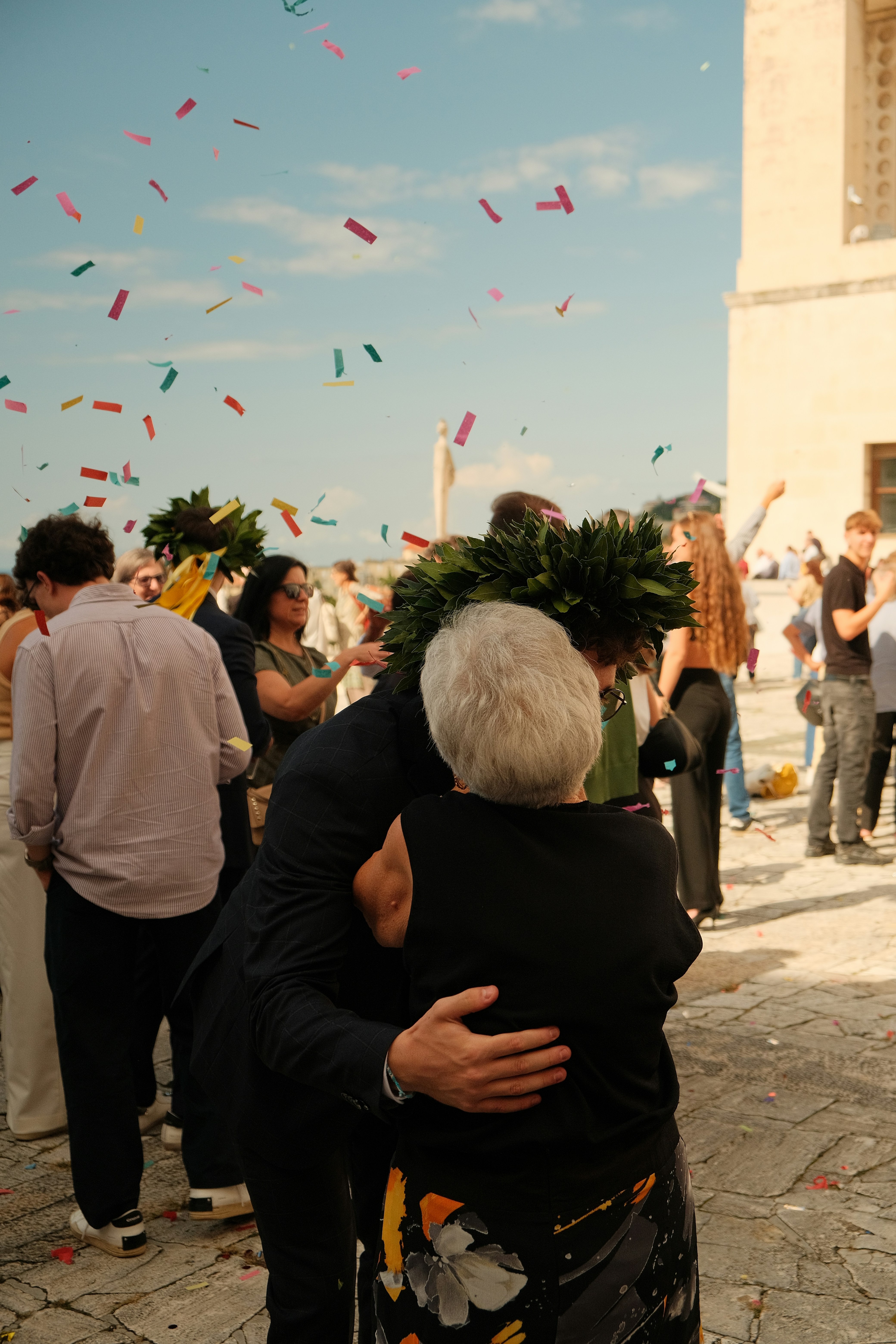 People celebrating with confetti and laurel wreaths