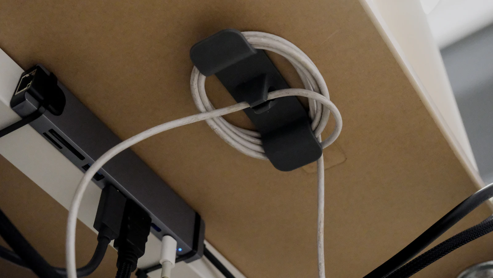Organisateur de câbles fixé sous un bureau