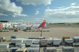 Airplane at airport gate with luggage carts