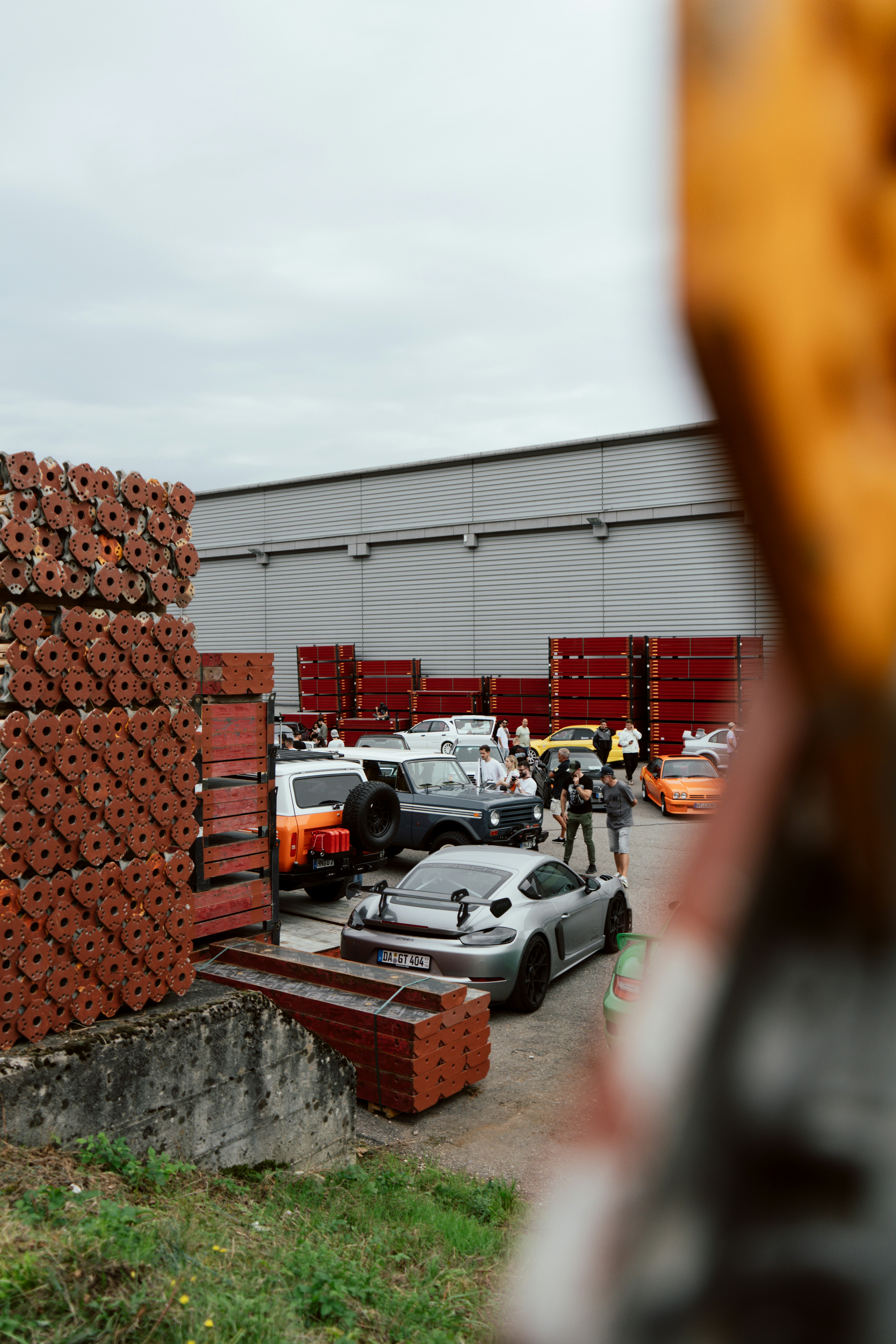 Diverse auto parcheggiate all'esterno di un magazzino con capannone industriale.